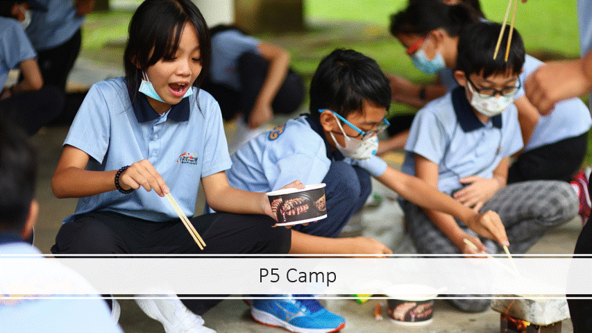 Students in blue uniforms and face masks sit outdoors doing a hands-on activity with chopsticks at P5 Camp.